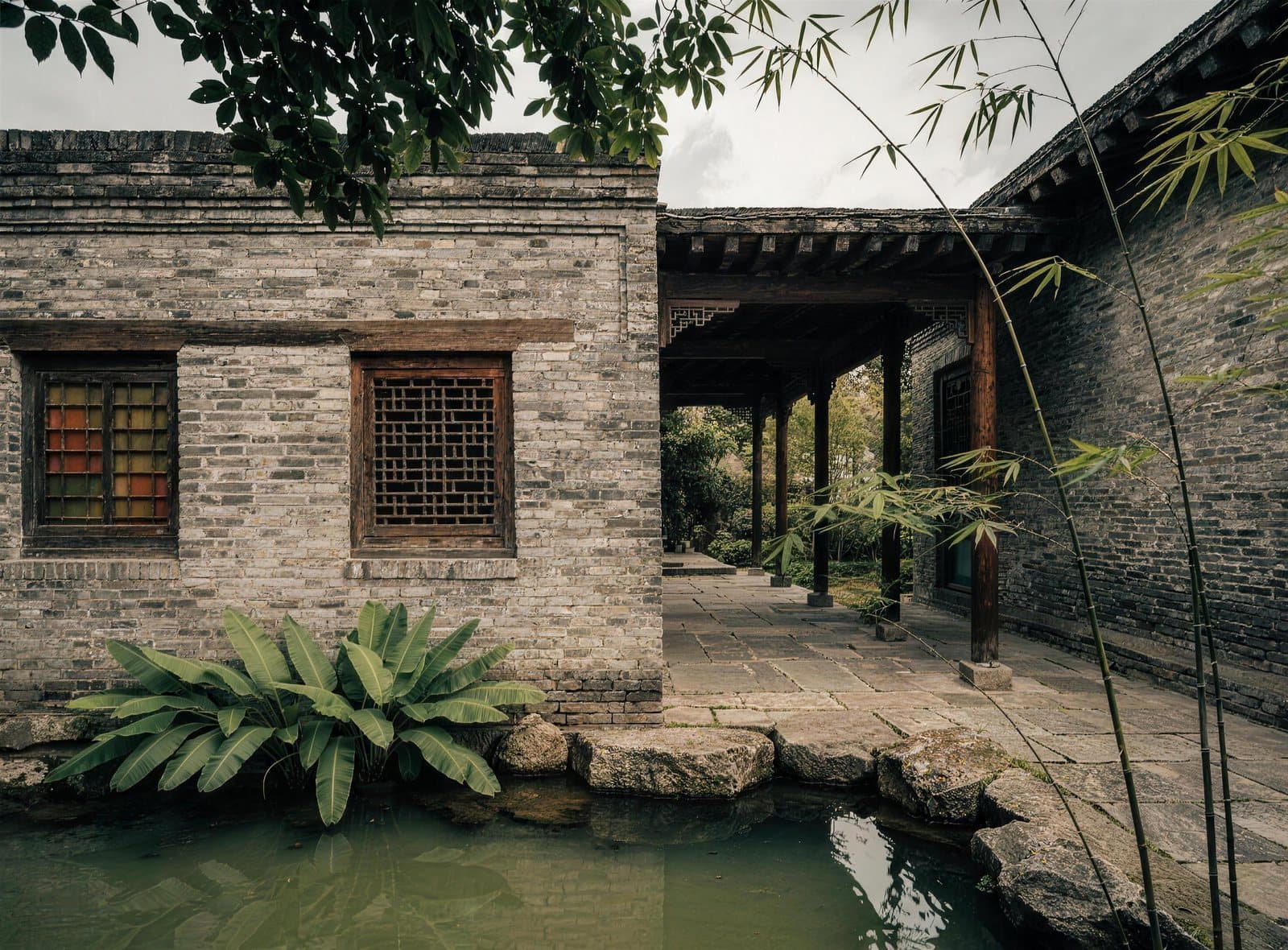 Innergård i en klassisk Lingnan-trädgård med gallerfönster och damm