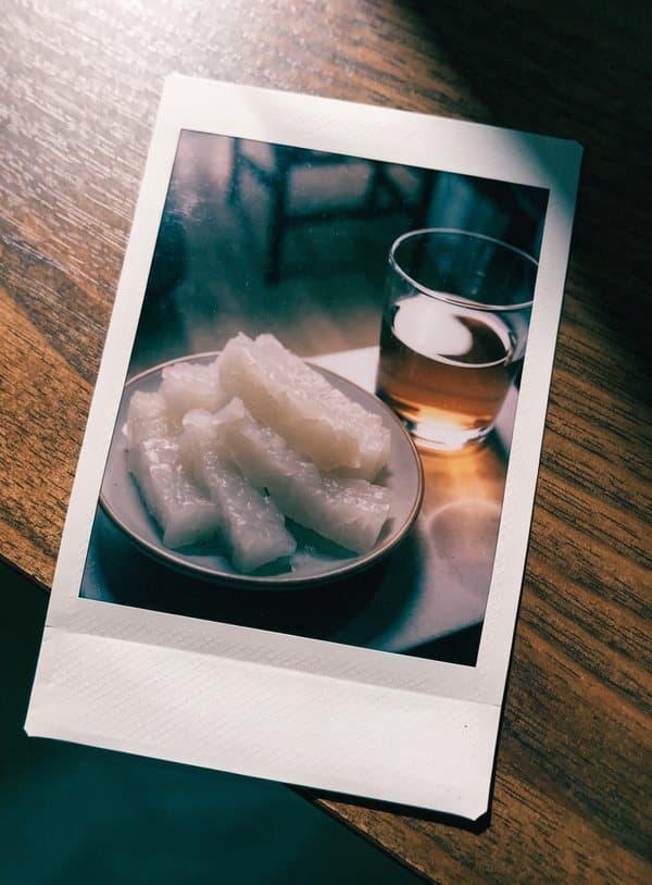 Polaroid av Lunjiao-kaka, vit rismjölkskaka, och ett glas te