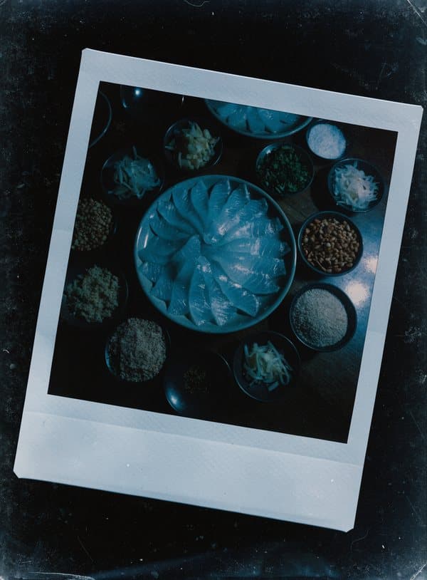 Polaroid av rå fisk på Shunde-vis med små skålar med tillbehör