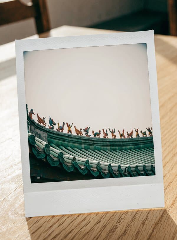 Polaroid av ett keramiktak med små figurer på ett tempel i Lingnan-stil